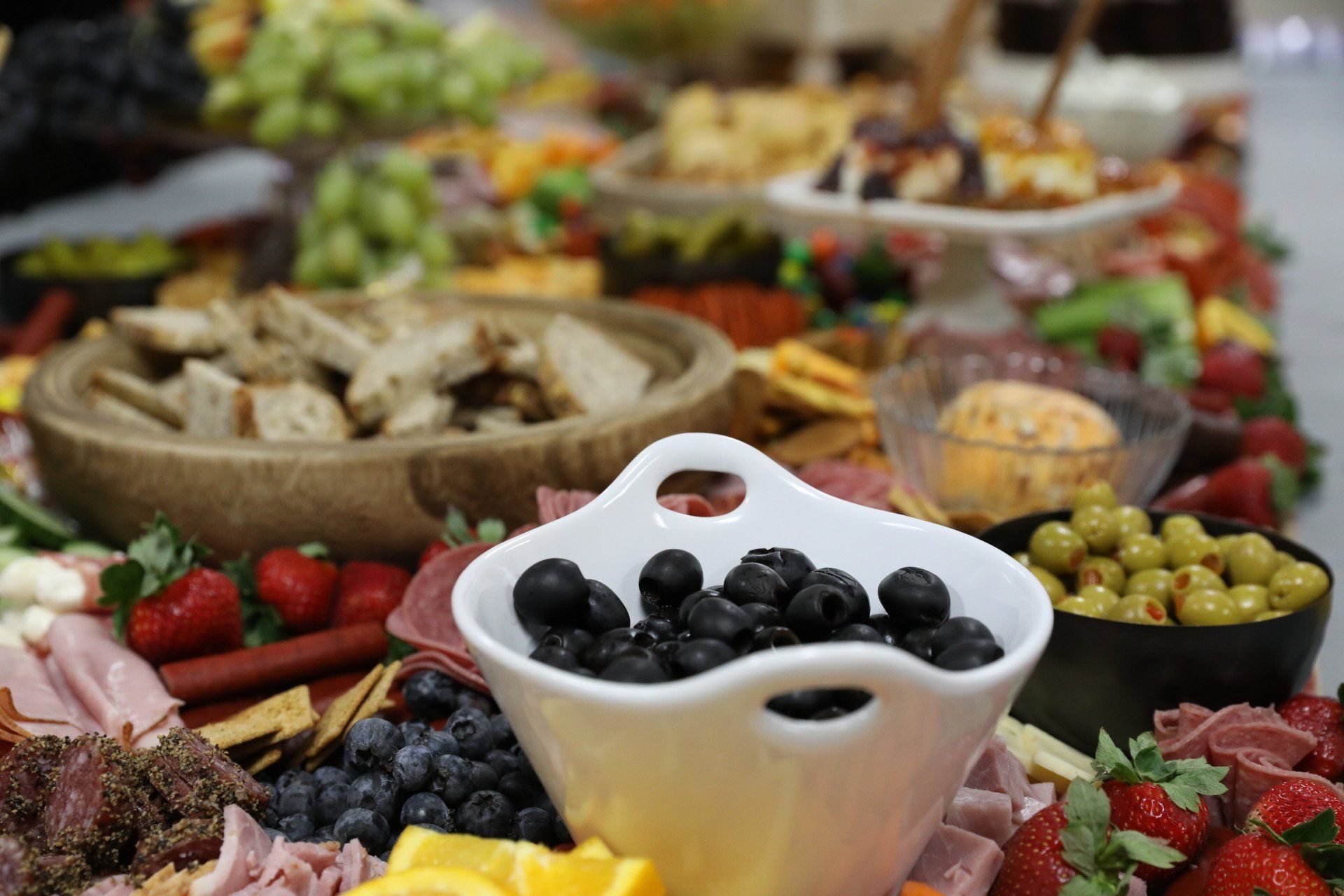 A buffet table with a bowl of blueberries on it.