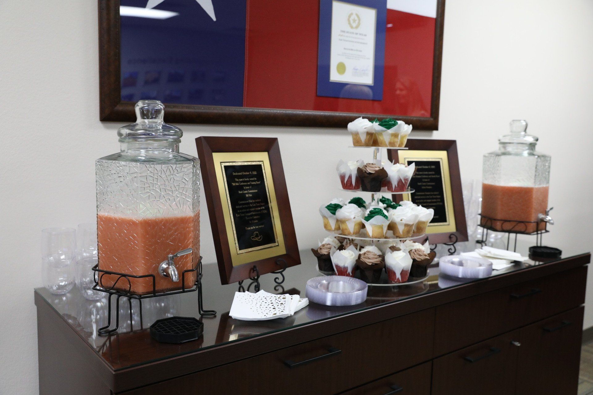 A table with drinks and cupcakes on it
