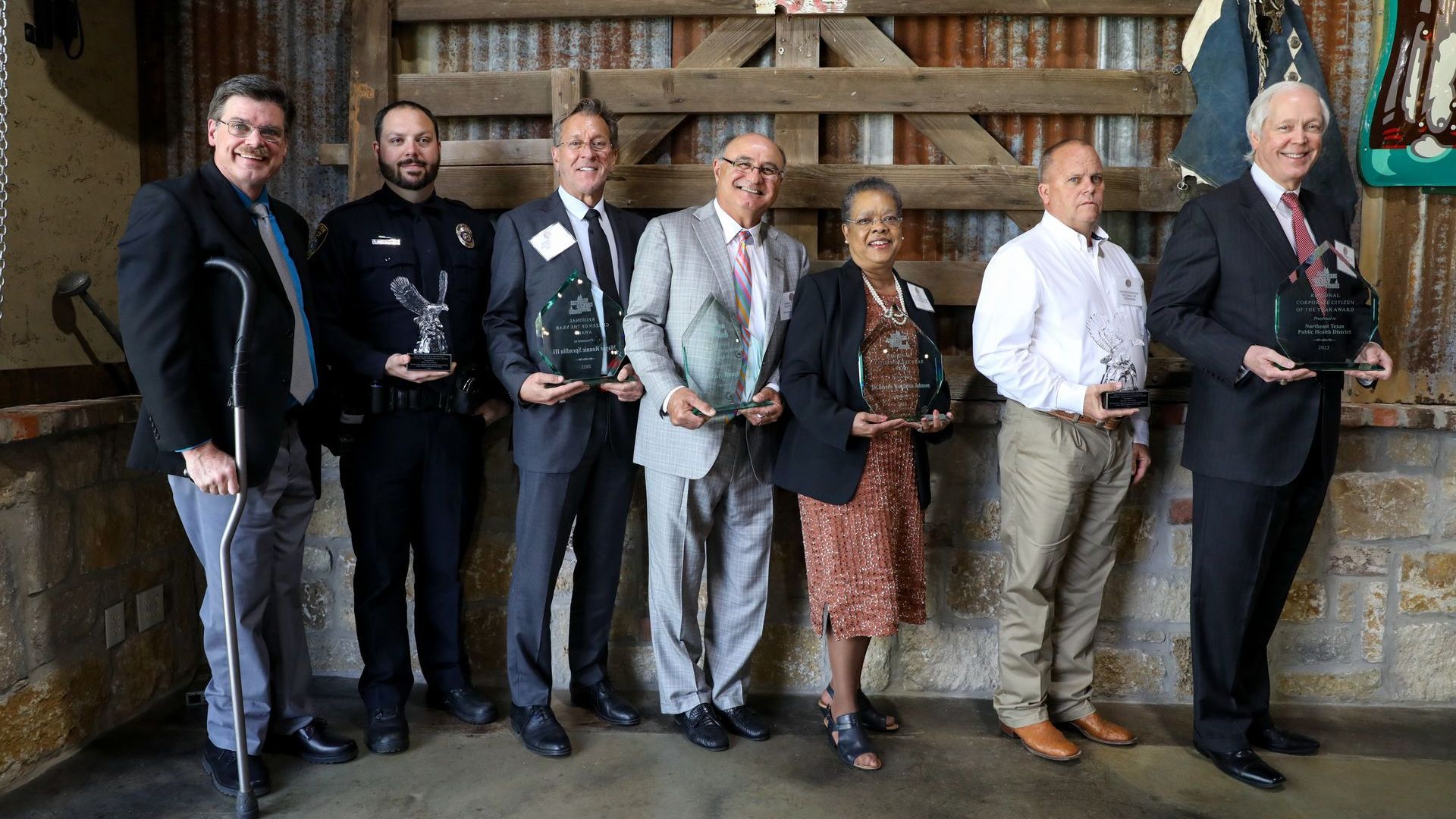 A group of people standing next to each other holding awards.