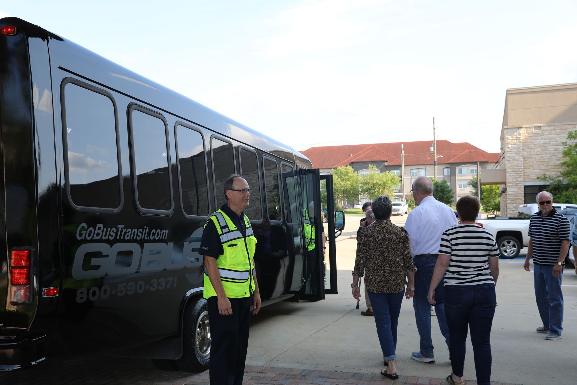 A group of people are walking towards a bus that says gone