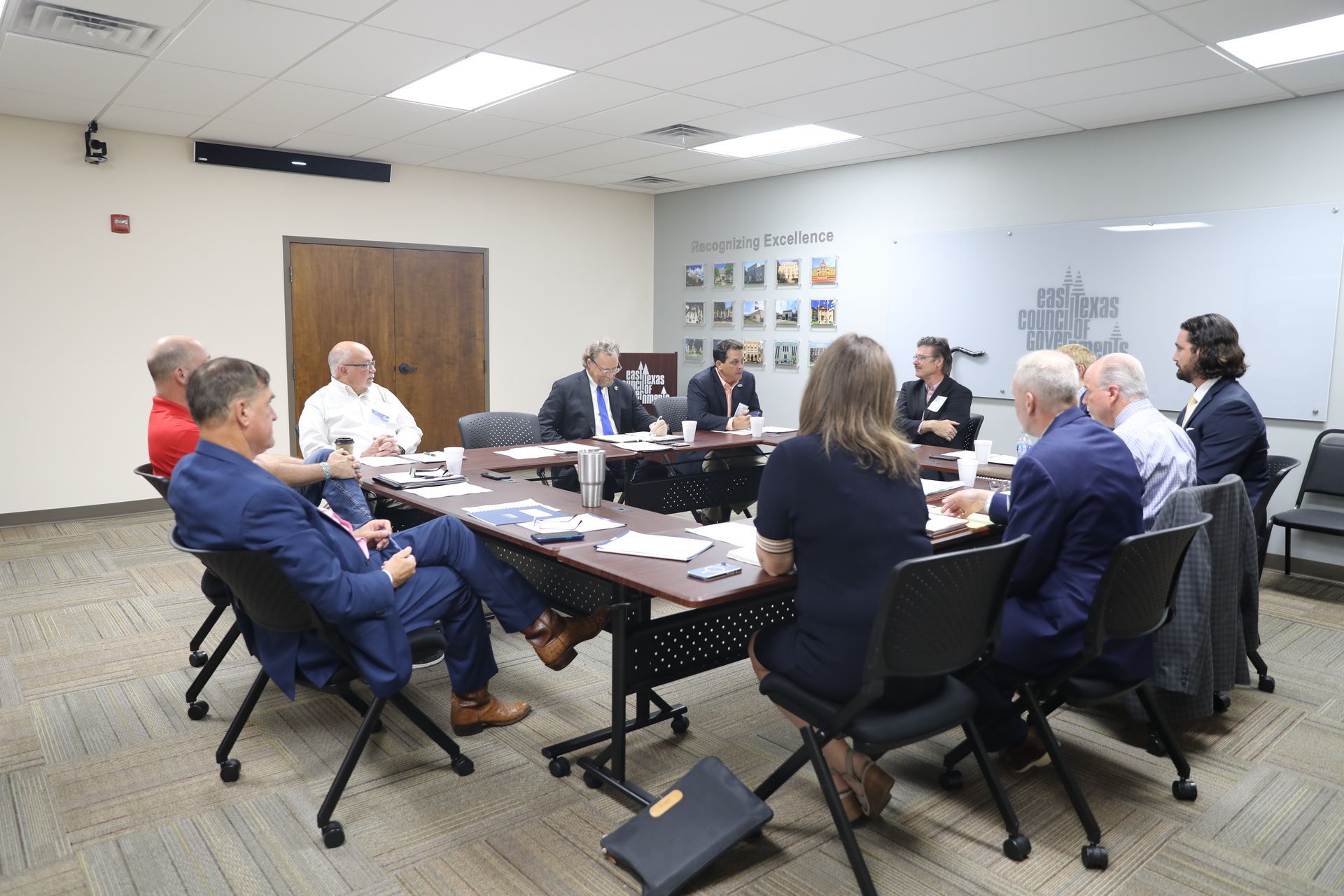 A group of people are sitting around a table having a meeting.