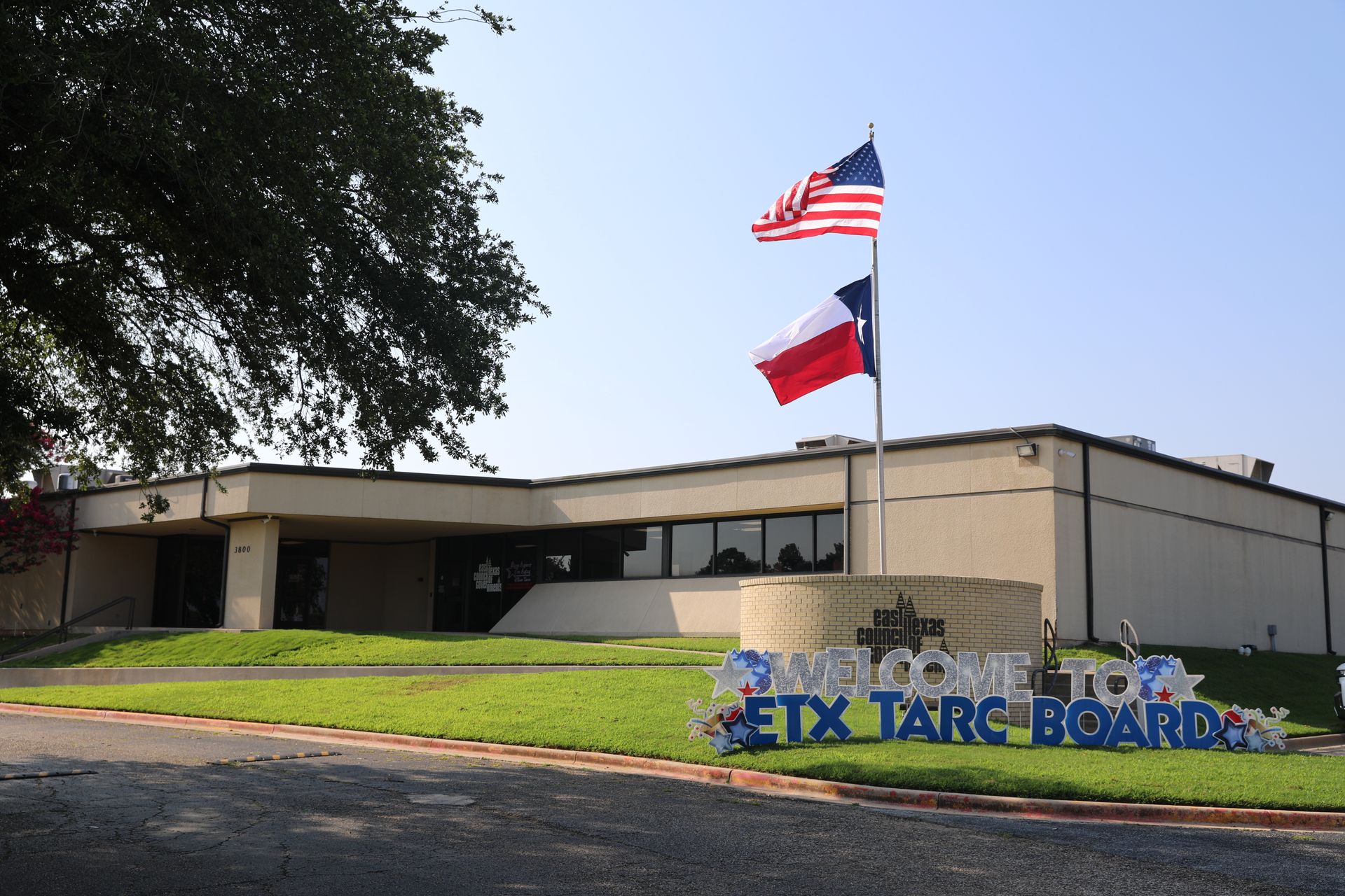 A building with two flags and a sign that says etx targ board