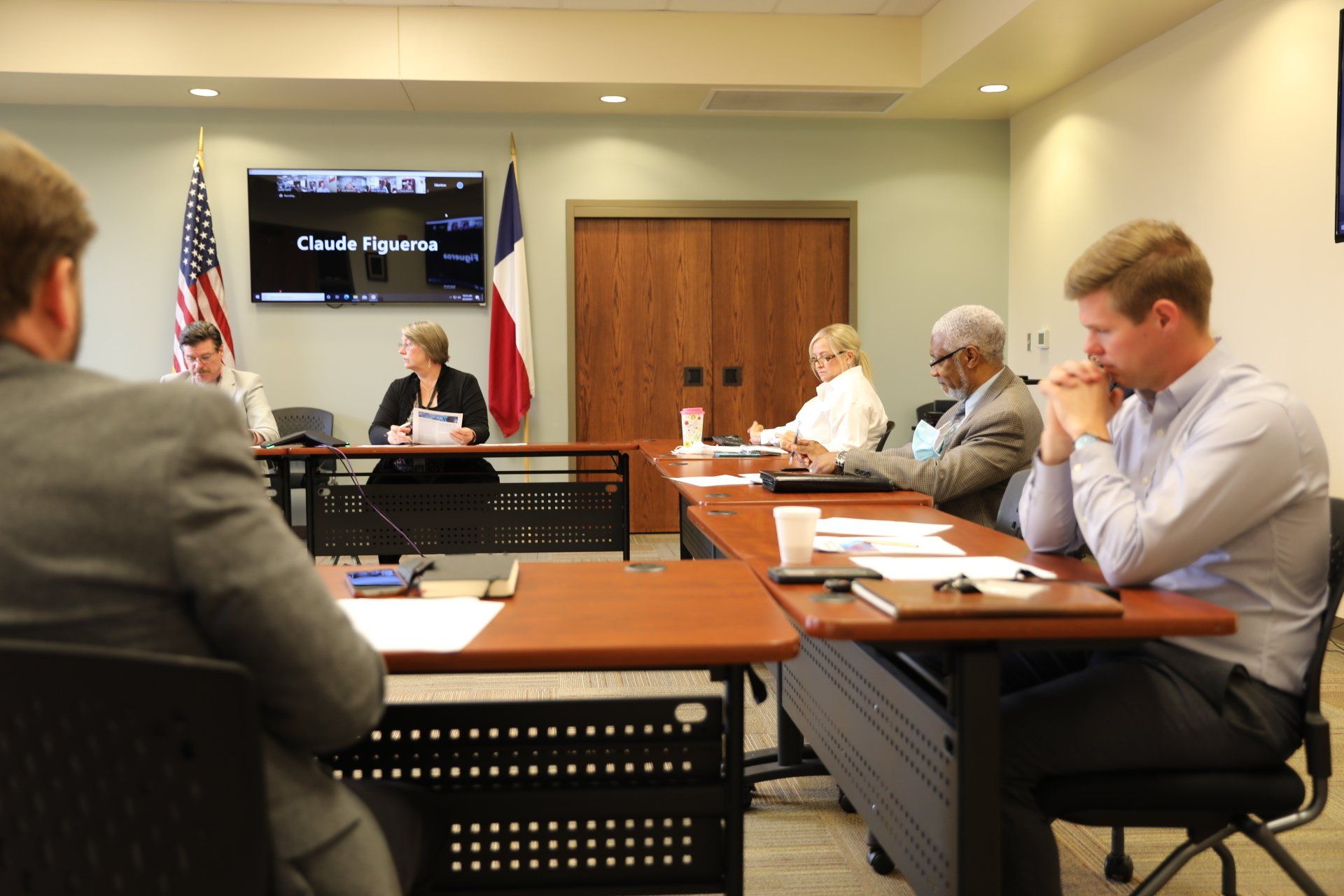 A group of people are sitting at tables in a conference room.