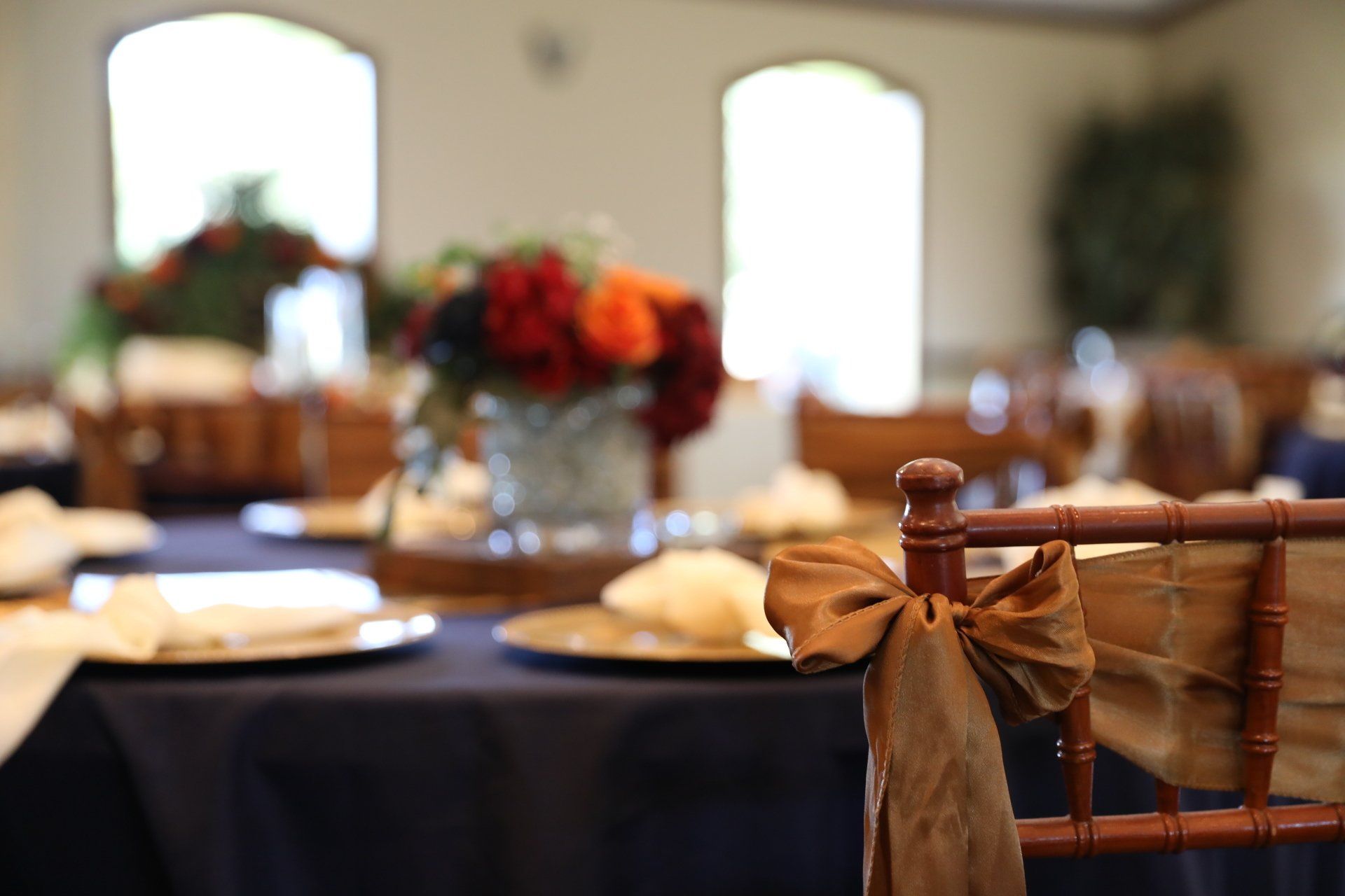 A chair with a bow on it is sitting in front of a table.