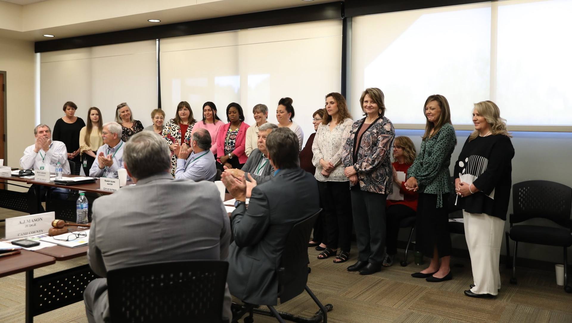 A group of people are standing around a table in a room.
