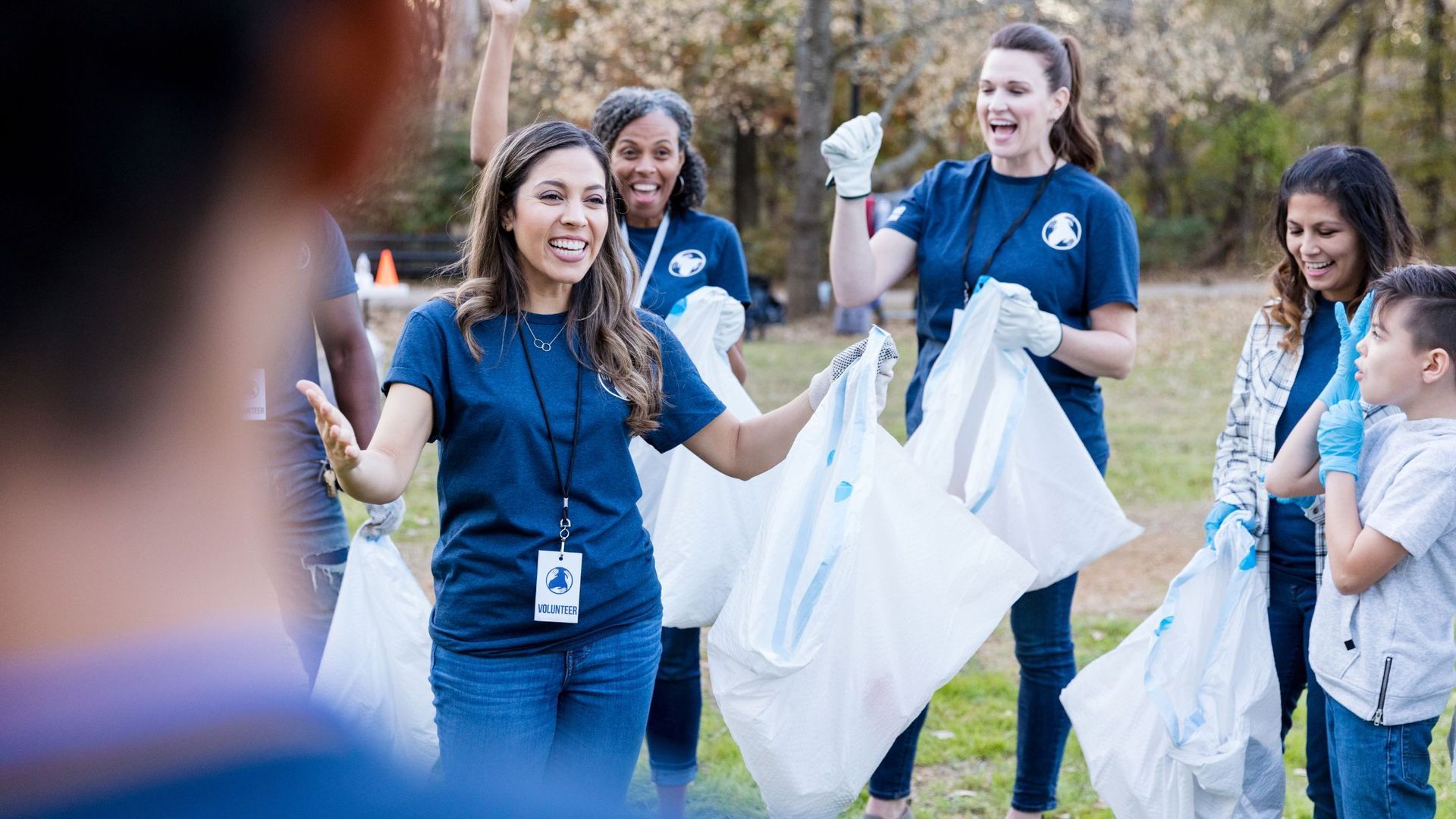 A group of people are standing in a circle holding trash bags.