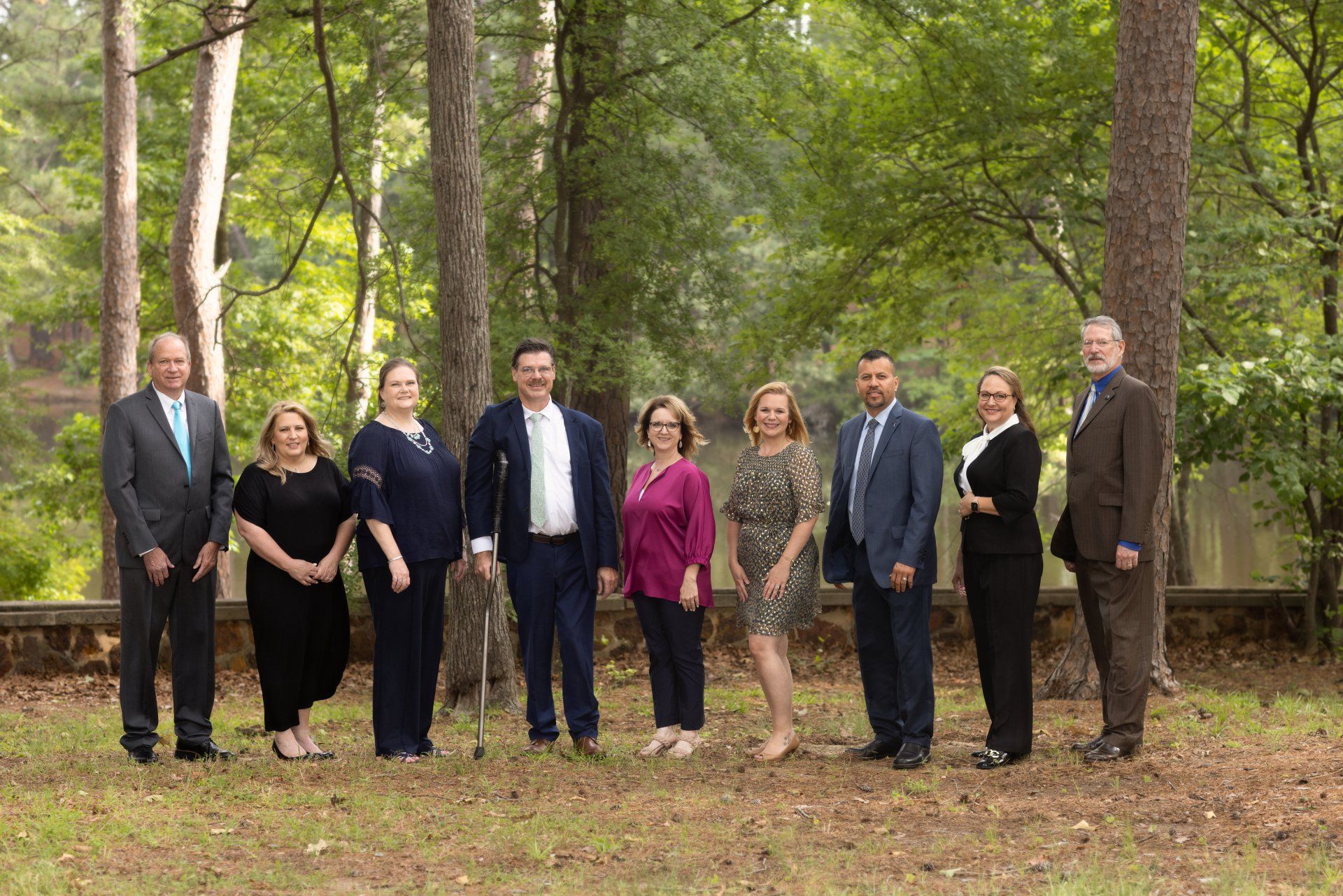 A group of people are posing for a picture in the woods.