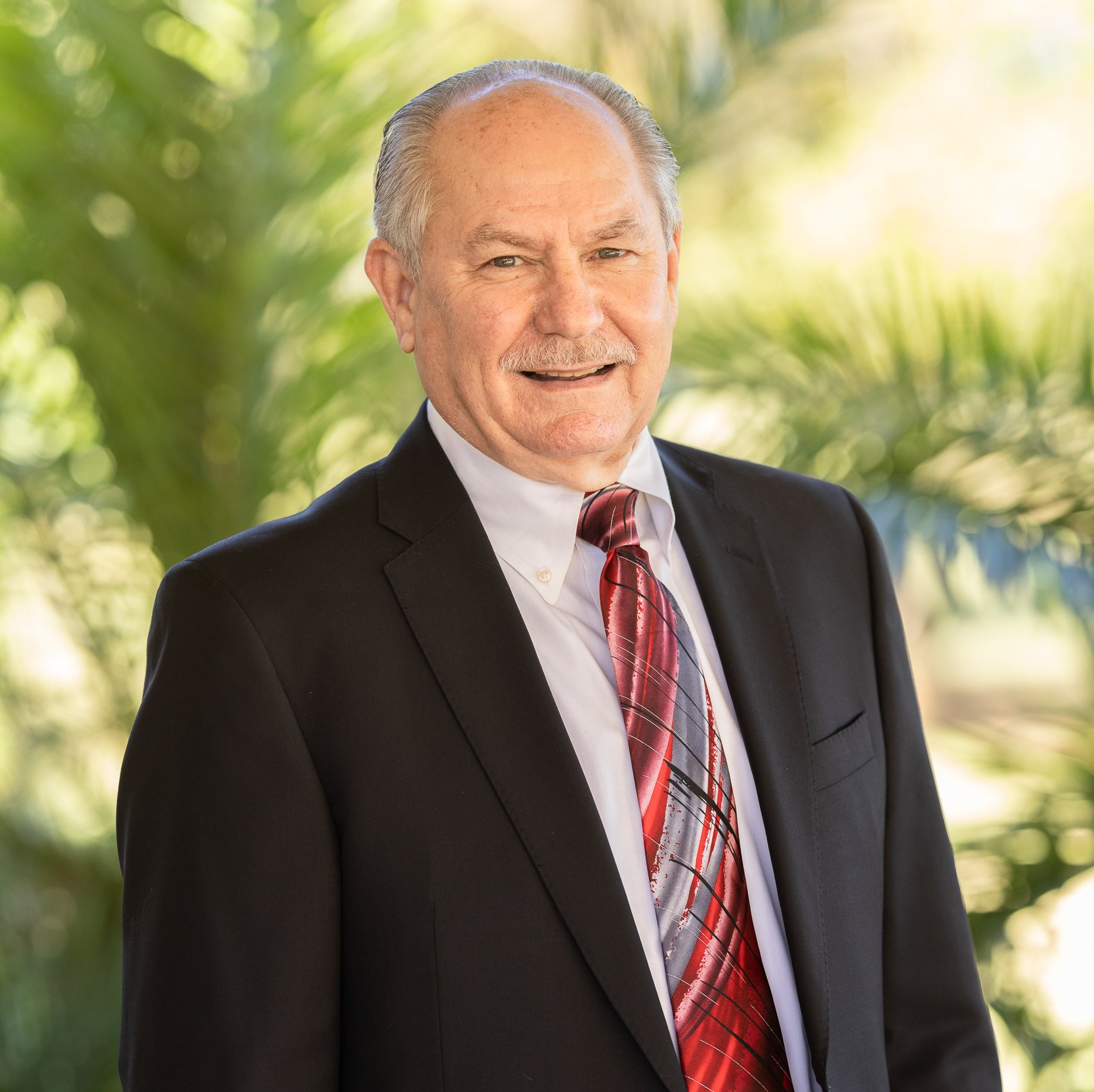 A man in a suit and tie is smiling for the camera.