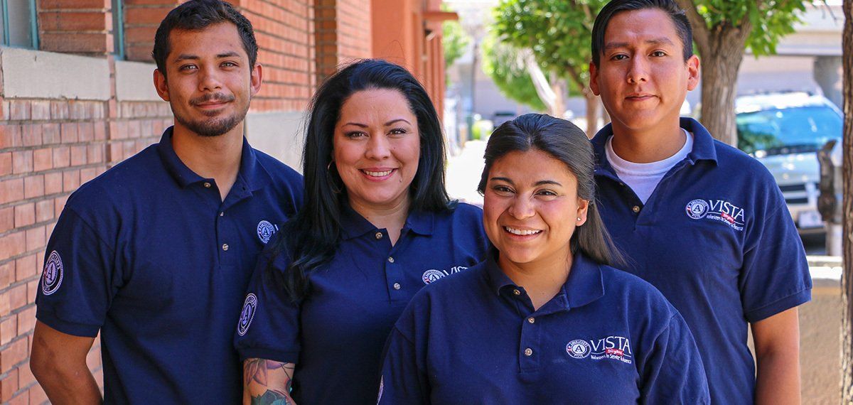 A group of people wearing blue polo shirts are posing for a picture.