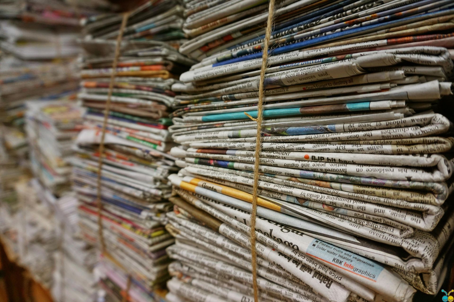 Bundled stacks of newspapers, tied with twine, ready for recycling.
