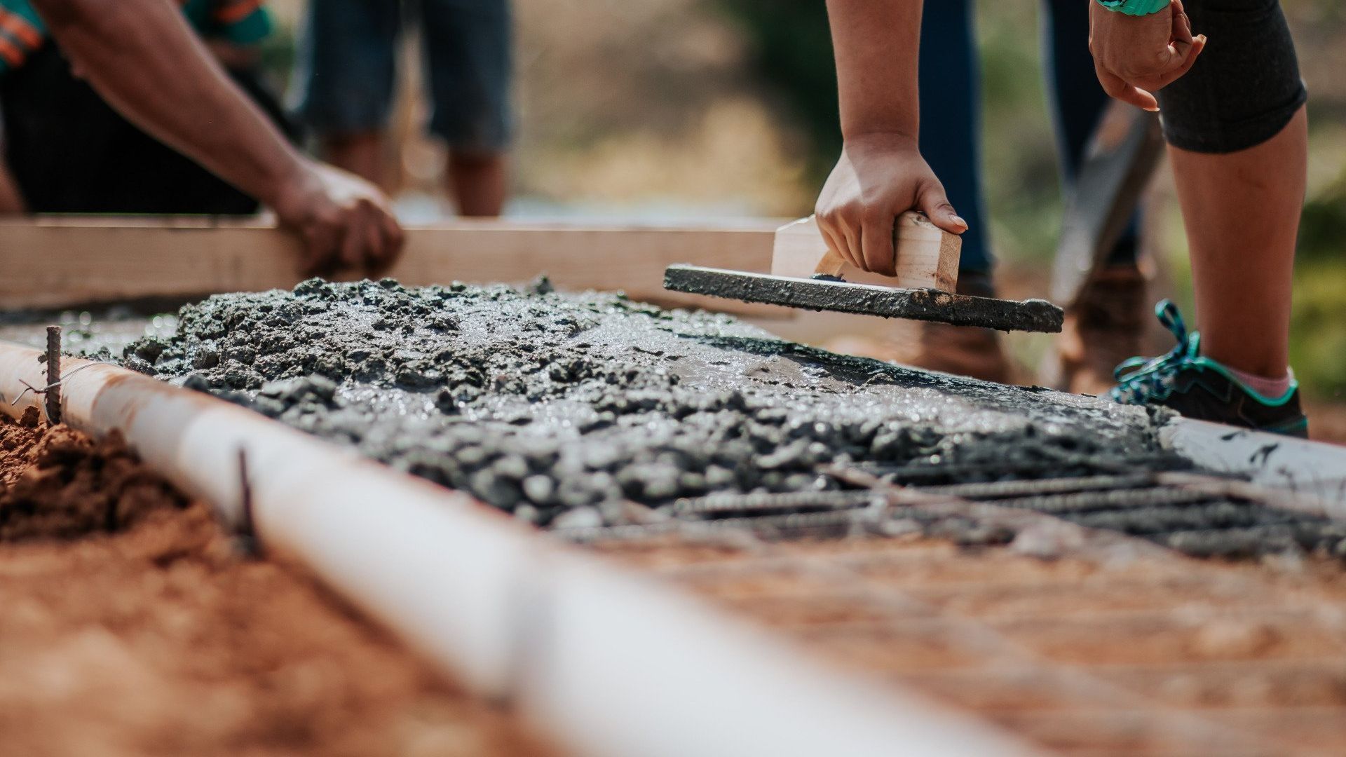 A group of people are working on a sidewalk.