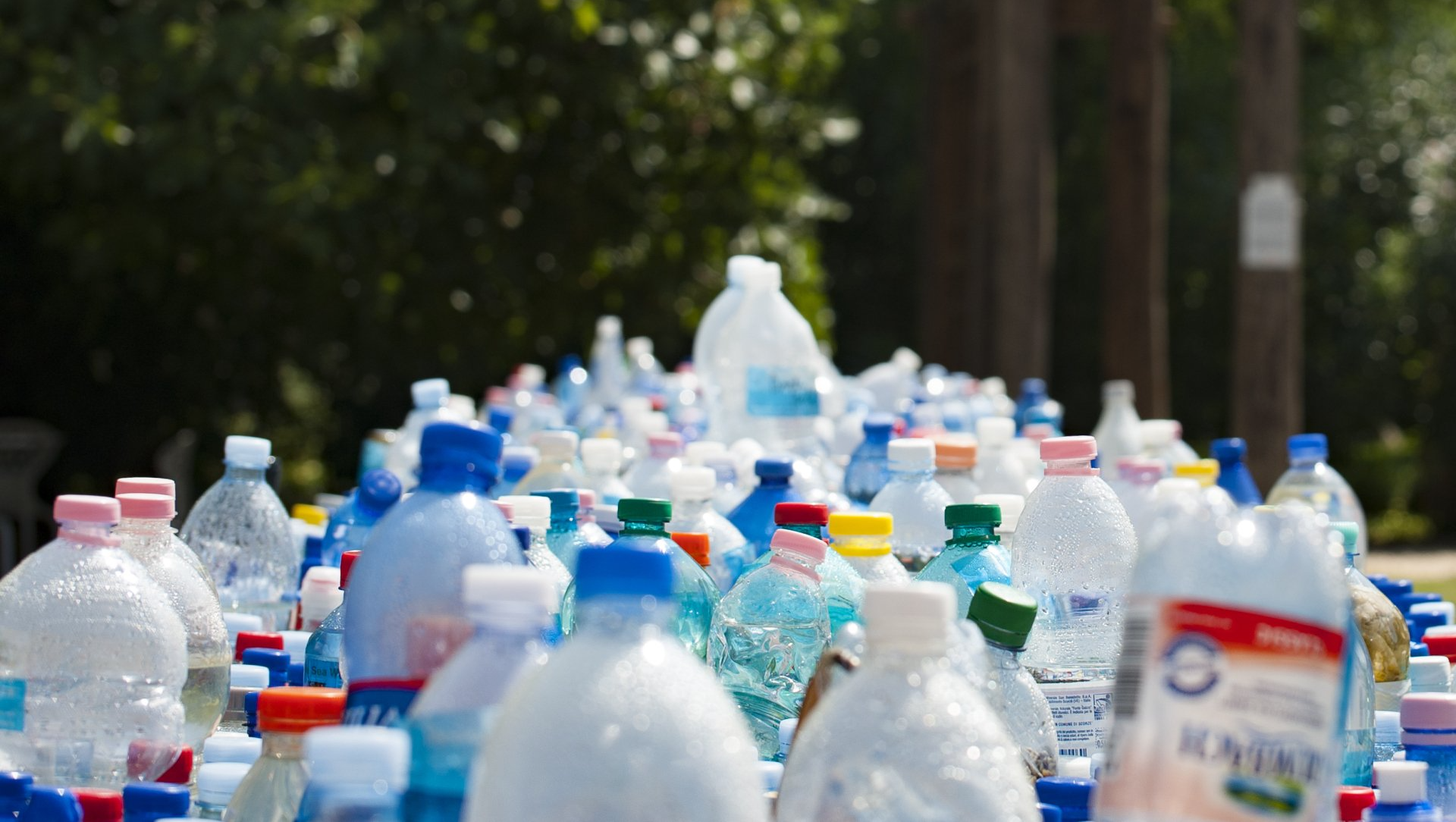A bunch of plastic bottles are sitting on top of each other on a table.