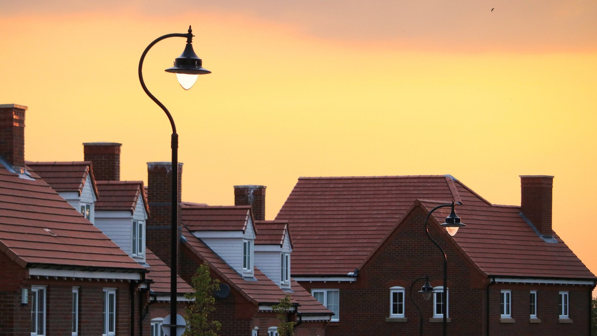 A row of houses with a street light in the foreground