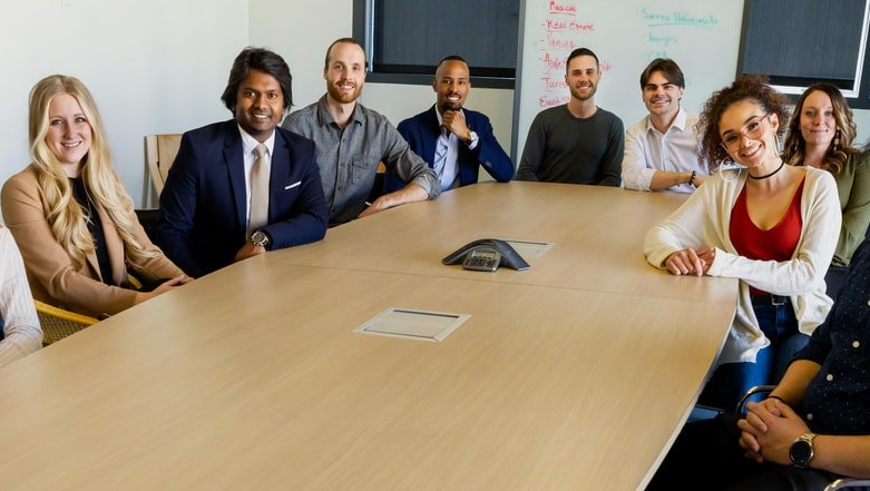 A group of people are sitting around a conference table.