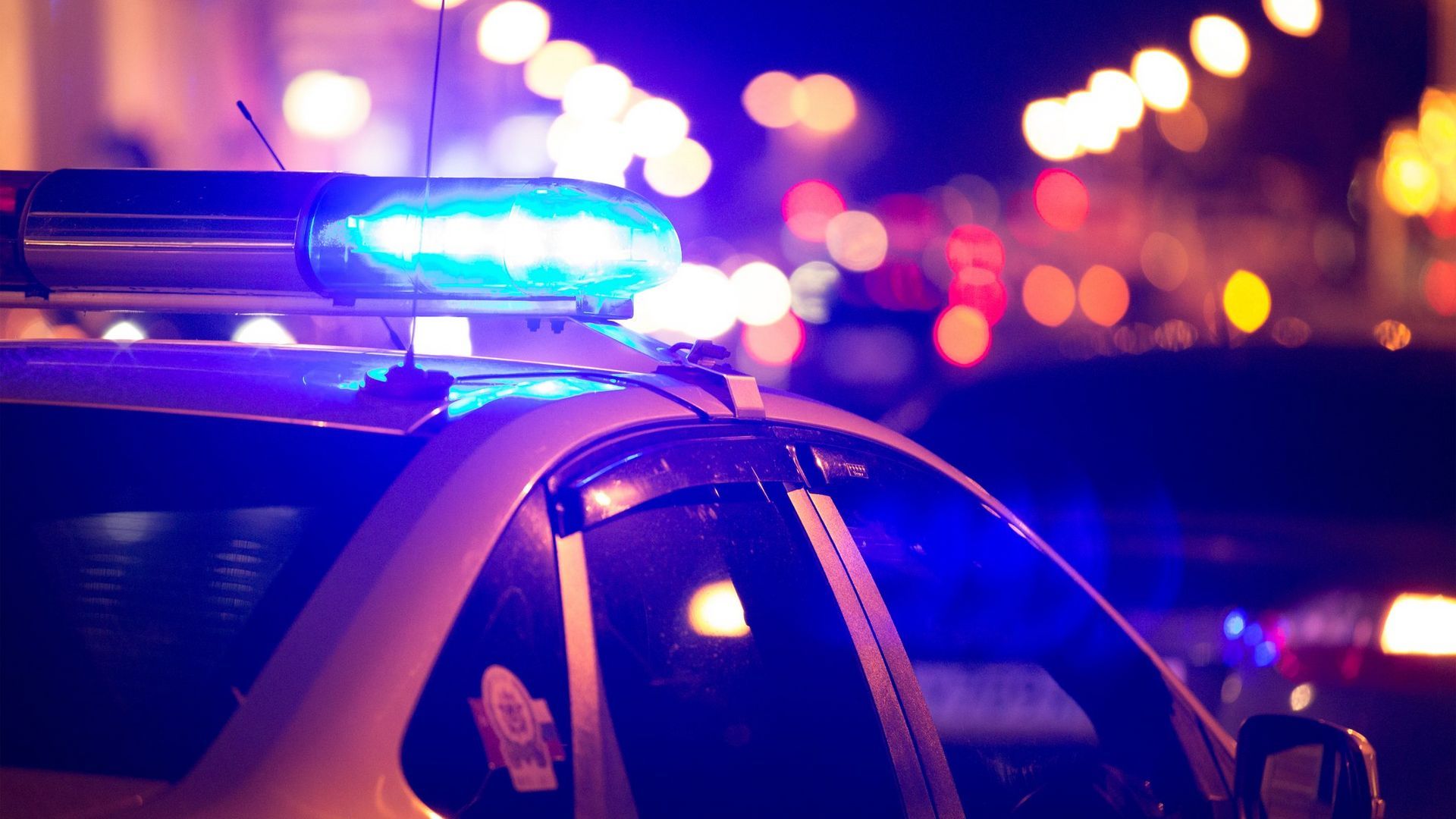 A police car with blue lights on top of it at night.