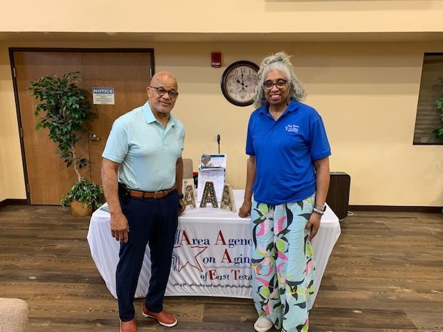 A man and a woman are standing in front of a table.