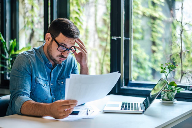 A man feels stressed as he reviews a denied claim, illustrating how a life insurance lawyer can help navigate challenges.