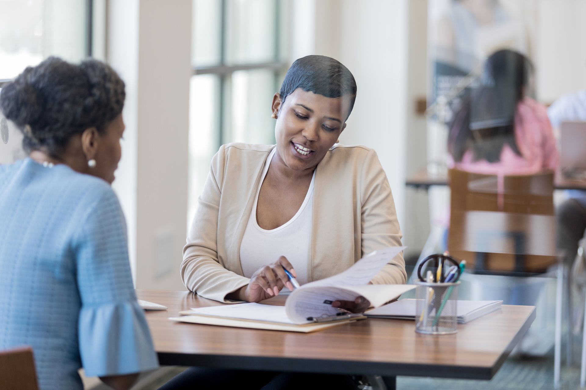 A lawyer discussing a car accident case with a client, reviewing legal documents in a professional office setting.
