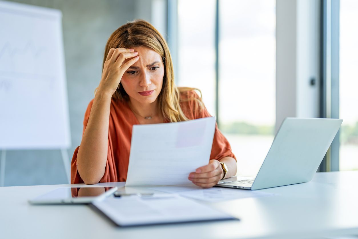 A concerned employee reviewing documents at a desk, symbolizing uncertainty about employment rights.