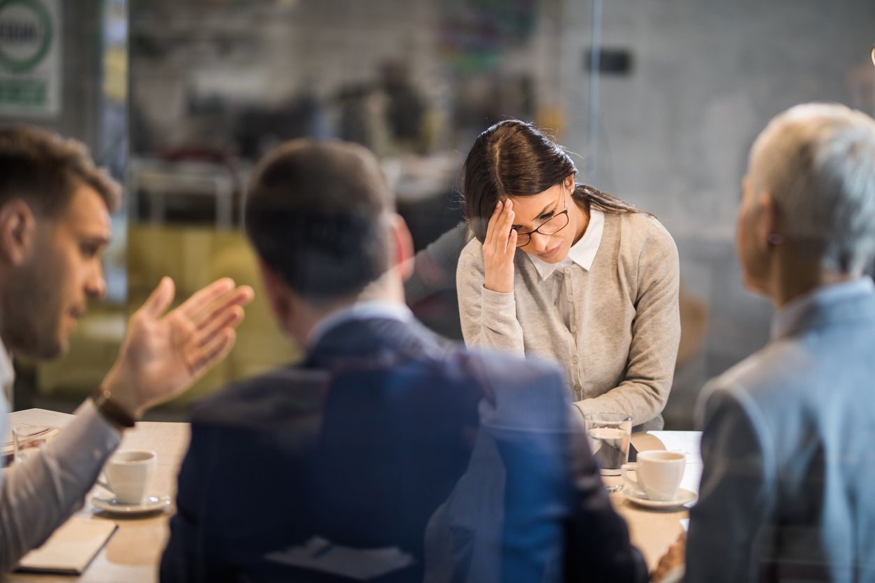 A workplace meeting where an employee appears distressed, illustrating the challenges of a toxic work environment.