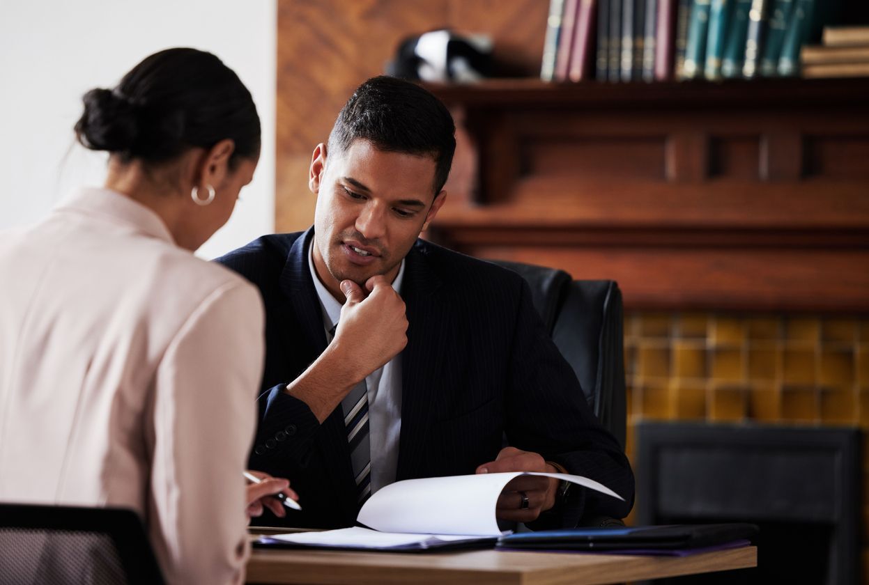 A lawyer and client reviewing documents together in a professional office, representing legal guidance and support.