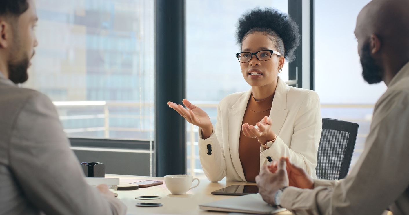 A professional life insurance lawyer, sitting at a desk in an office setting, discusses claim options with two clients.