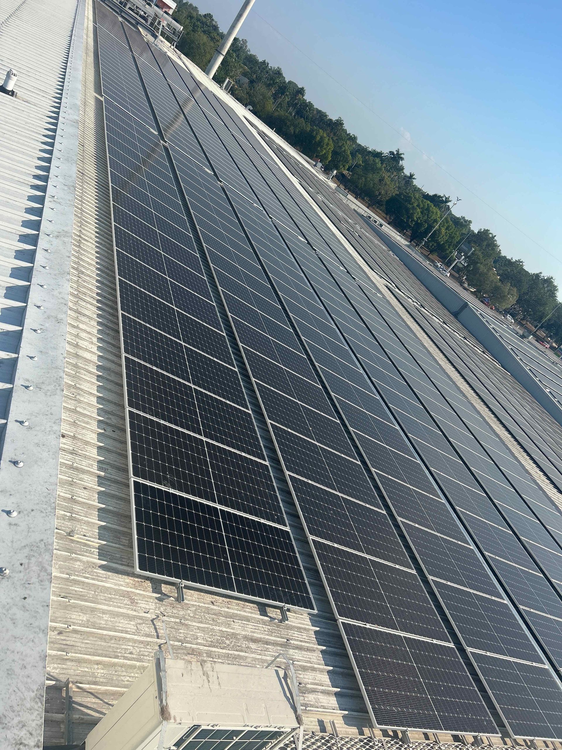 A Person Is Installing a Solar Panel on A Roof — Eco Sparks Solar & Electrical Contractors in Berrimah, NT