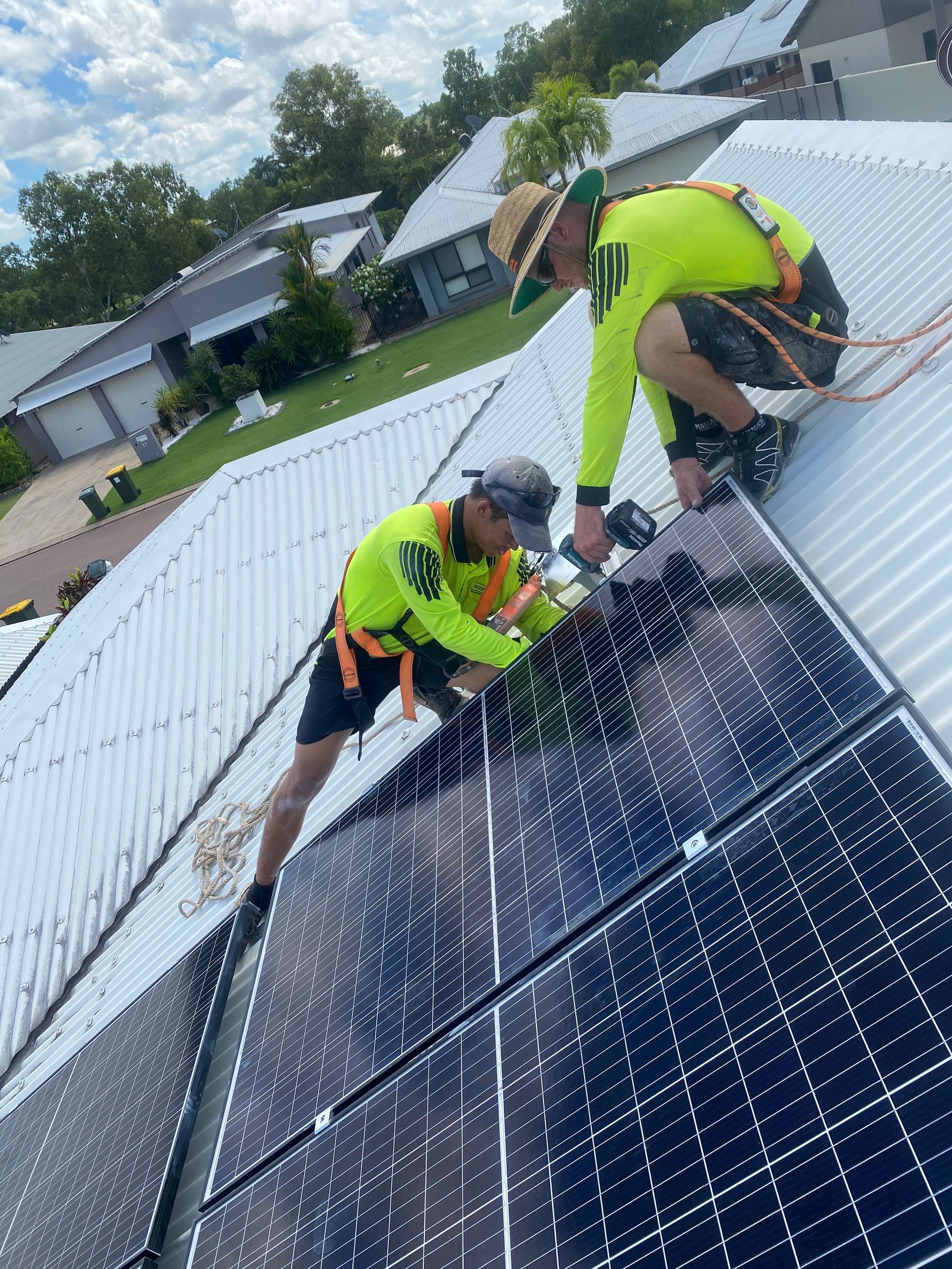 Two Men installing Solar Panels on the roof — Eco Sparks Solar & Electrical Contractors in Berrimah, NT