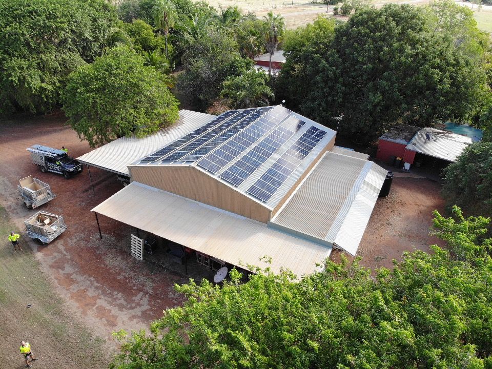 A Row of Solar Panels Sitting on Top of A Dirt Field — Eco Sparks Solar & Electrical Contractors in Berrimah, NT