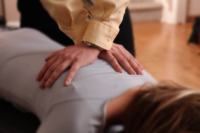 Hands pressing on a person’s back during a massage or physical therapy session