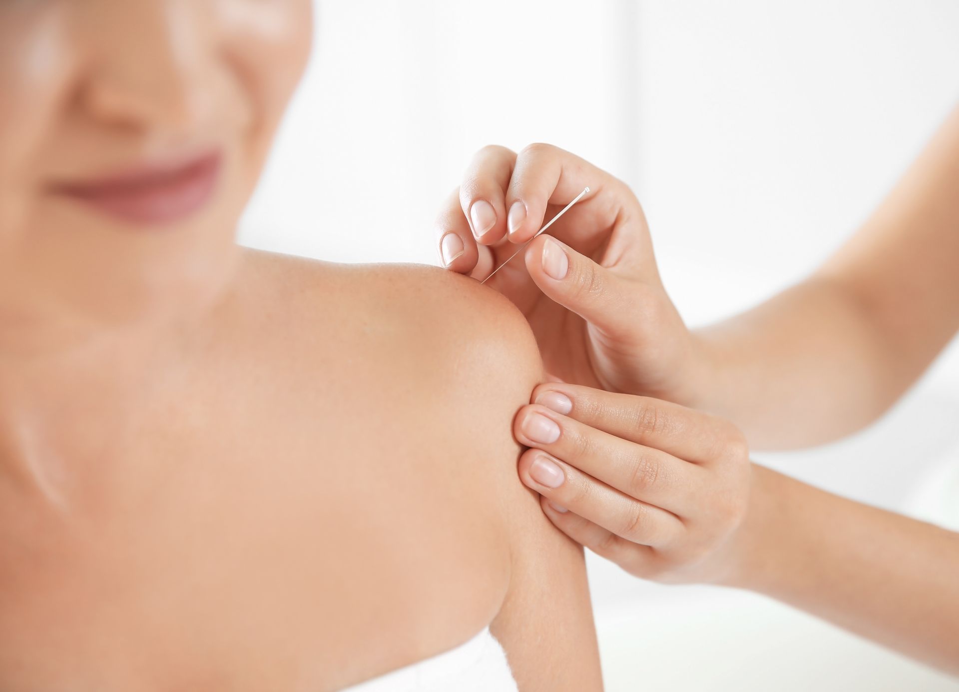 Hands applying a shot to a person’s shoulder during a vaccination.