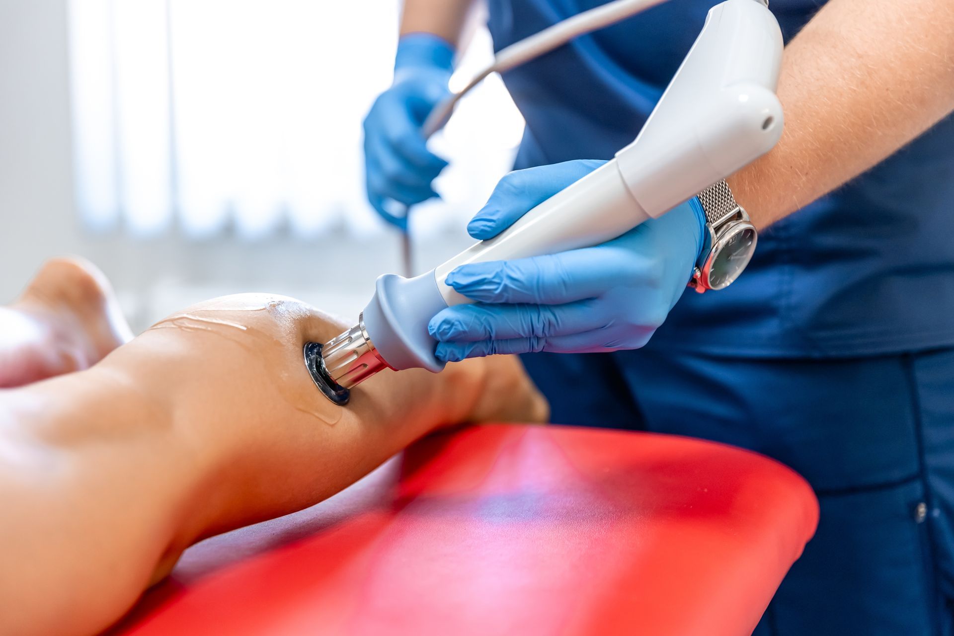 Medical staff using ultrasound probe on a patient’s ankle in a clinic