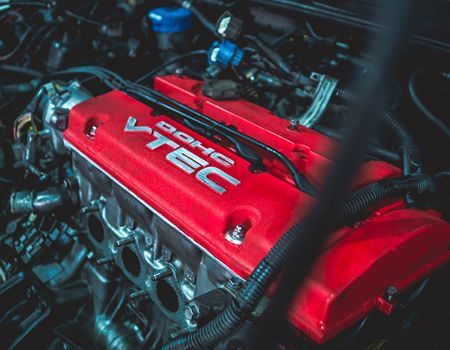 Close-up of a red Honda VTEC engine cover in a car engine bay