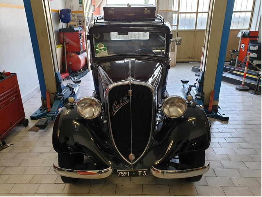 Vista frontale di un'auto nera d'epoca parcheggiata in un garage