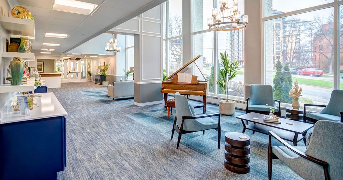 Spacious, well-lit lobby with piano, seating, and large windows looking outside.
