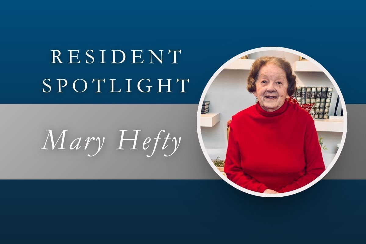 Resident Spotlight: Mary Hefty, wearing a red sweater, smiles in front of a shelf in a white-rimmed circle.