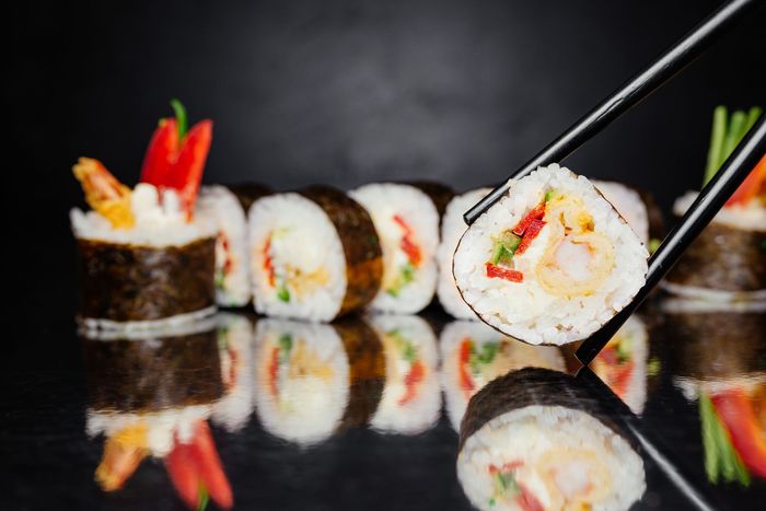 Chopsticks holding Roll Sushi — Vineland, NJ — Tang Asian Cuisine Chopsticks holding Roll Sushi — Vineland, NJ — Tang Asian Cuisine