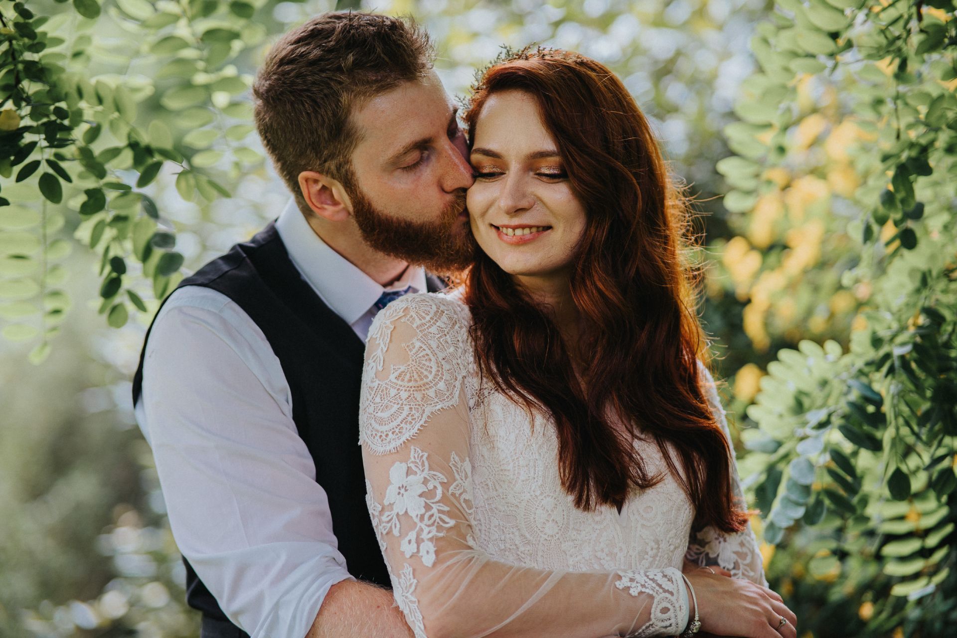 close up of married couple in the trees at outdoor wedding 