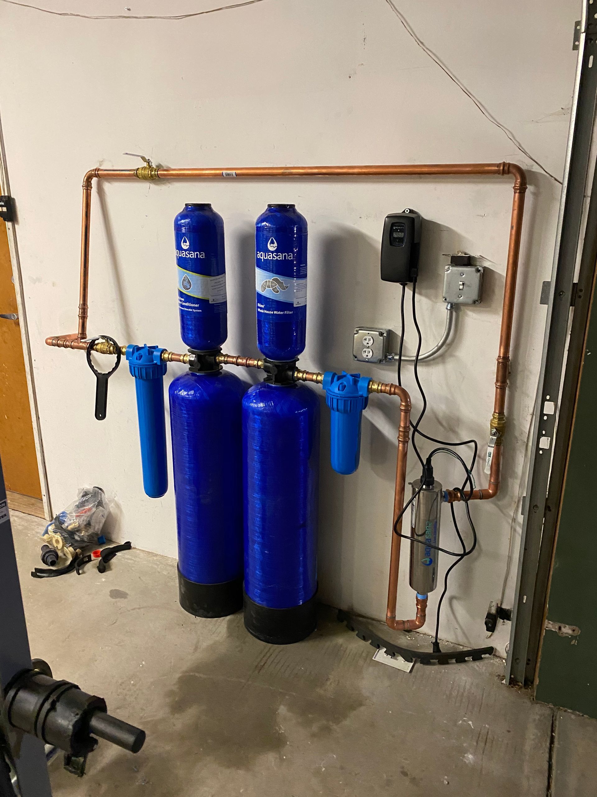 Two Blue Water Filters Are Sitting Next to Each Other on A Wall.