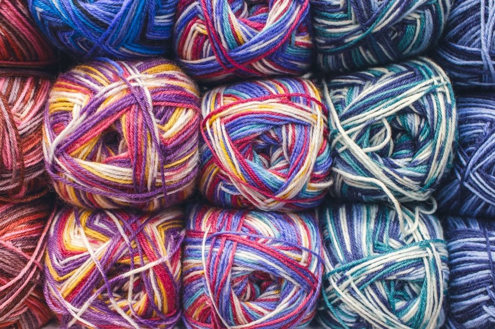 Colorful balls of variegated yarn, arranged in a grid.