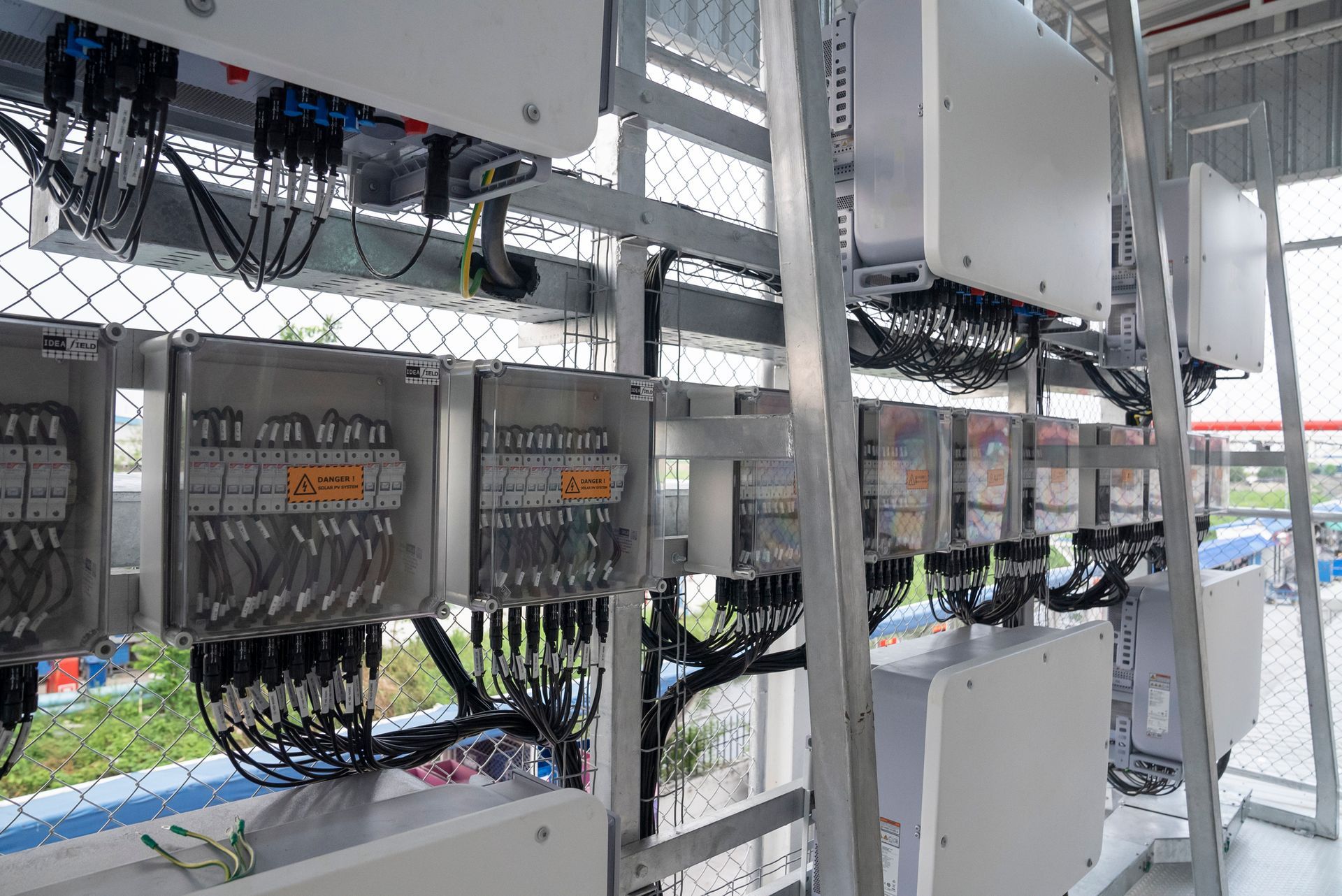 A row of electrical boxes hanging from the ceiling of a building.