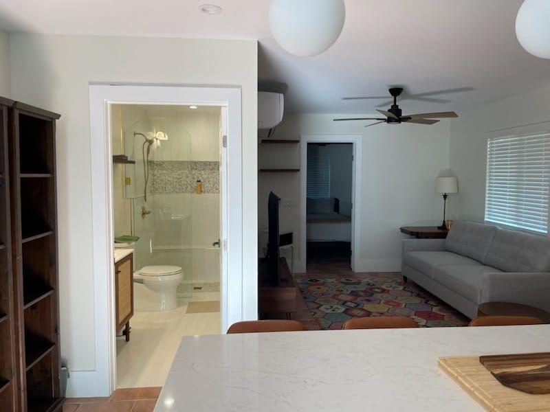 Open-concept living space with a bathroom, living room, and a hallway visible.