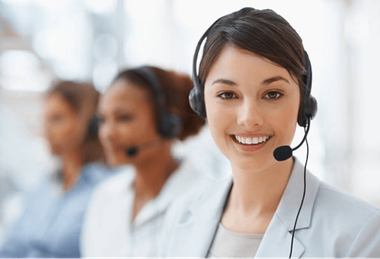 Call center agents wearing headsets, with a smiling woman in the foreground