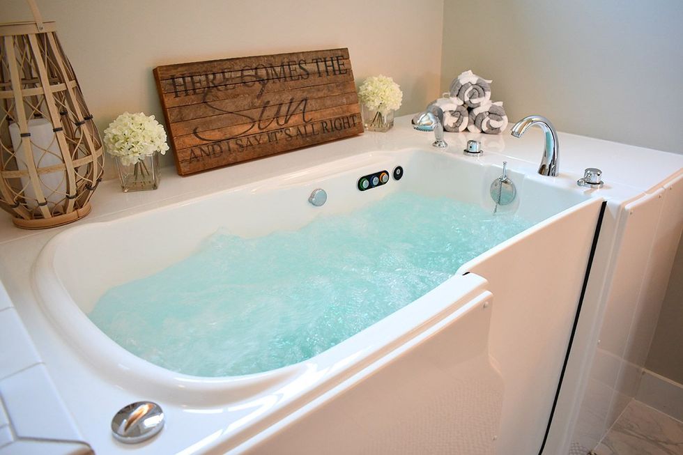 A walk in tub with a wooden sign on top of it.