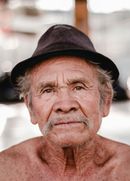 A close up of an older man wearing a hat.