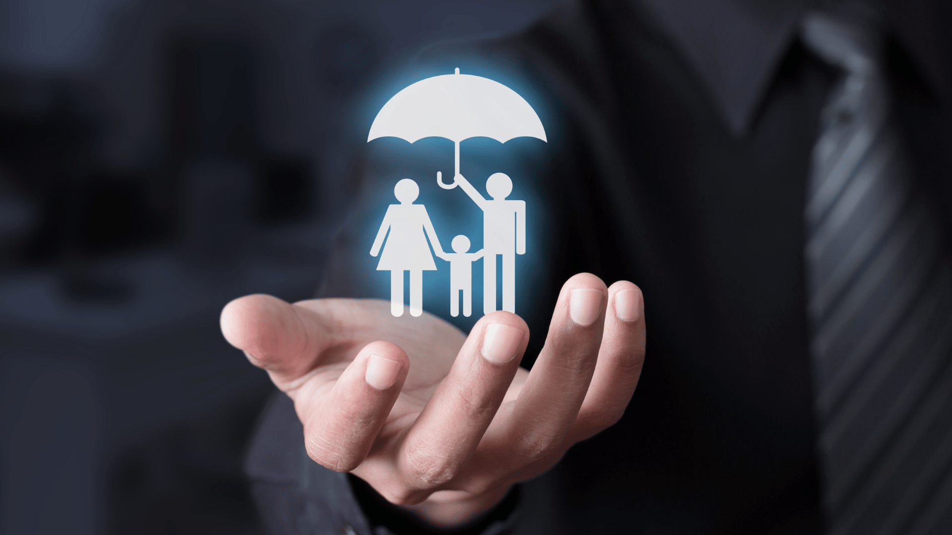 man's hand holding paper cutout of family with umbrella