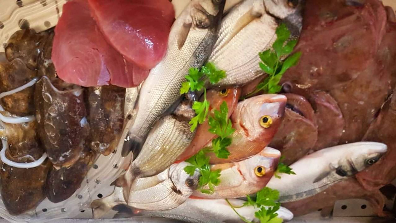 Una varietà di pesce e carne sono disposti su un tavolo.