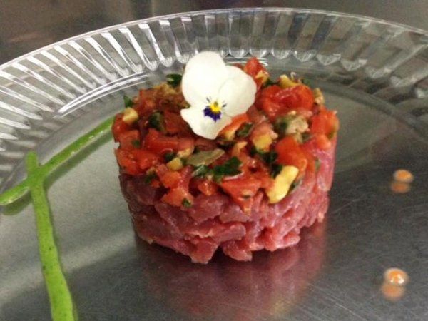 Un primo piano di un piatto di cibo con un fiore sopra