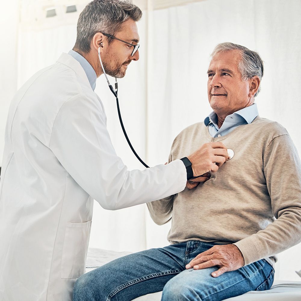 A doctor is listening to a patient 's heart with a stethoscope.