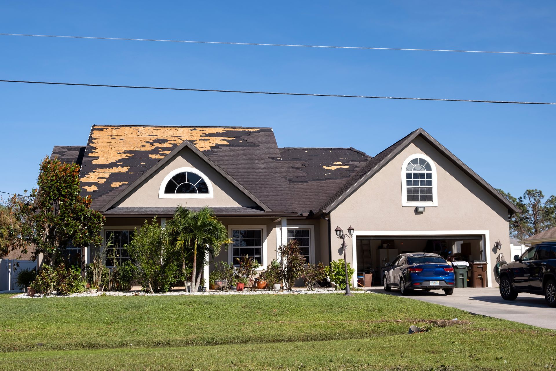 Suburban house with a manicured lawn and two cars parked in the driveway